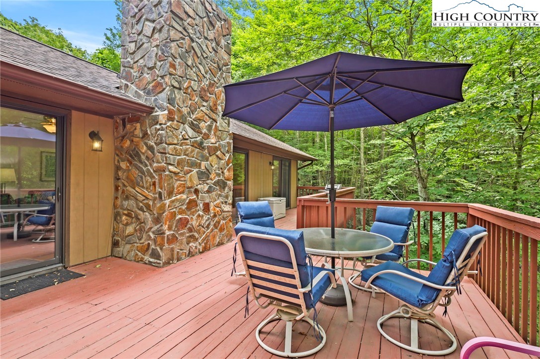 311 Pine Ridge Road Beech Mountain, NC 28604 - Photo 8 of 37 a patio with wooden floor a yard a table and chairs