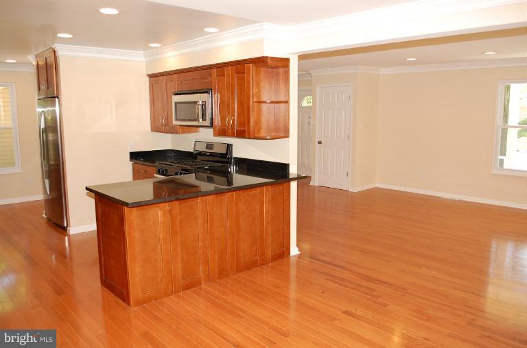 6216 Stevens Forest Road Columbia, MD 21045 - Photo 25 of 30 a kitchen with stainless steel appliances granite countertop a sink a stove and a refrigerator