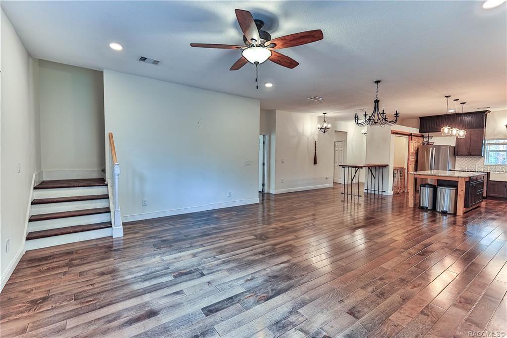 110 North Rooks Avenue Inverness, FL 34453 - Photo 11 of 34 a view of a room with wooden floor a ceiling fan and windows