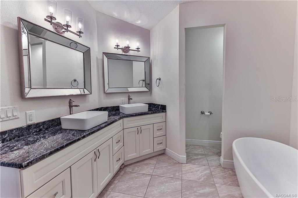 110 North Rooks Avenue Inverness, FL 34453 - Photo 31 of 34 a bathroom with a granite countertop sink a toilet and mirror