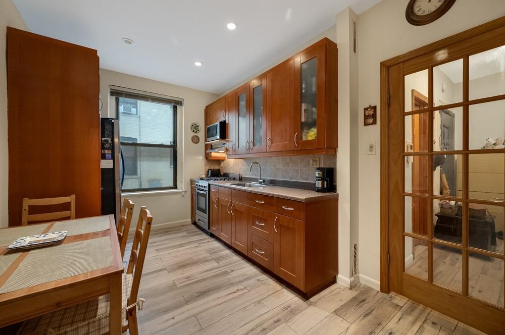 3045 Ocean Parkway, Unit 2D Brooklyn, NY 11235 - Photo 6 of 10 a kitchen with stainless steel appliances granite countertop a refrigerator and a stove top oven