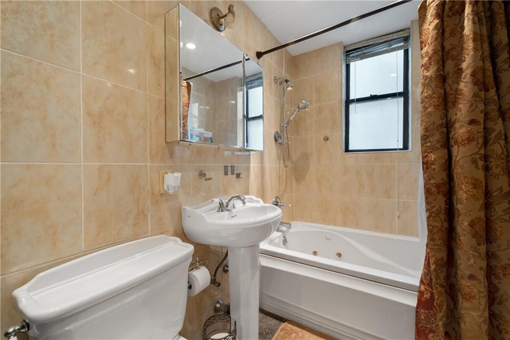 3045 Ocean Parkway, Unit 2D Brooklyn, NY 11235 - Photo 7 of 10 a bathroom with a sink toilet and shower