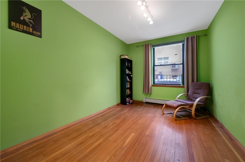 3045 Ocean Parkway, Unit 2D Brooklyn, NY 11235 - Photo 10 of 10 a view of a room with wooden floor a ceiling fan and windows