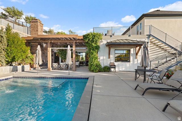 912 North Loafer Canyon Road Elk Ridge, UT 84651 - Photo 62 of 98 Expansive outdoor living area featuring a rectangular swimming pool with tiled coping, a wood-beam pergola, a brick chimney, and concrete patio decking