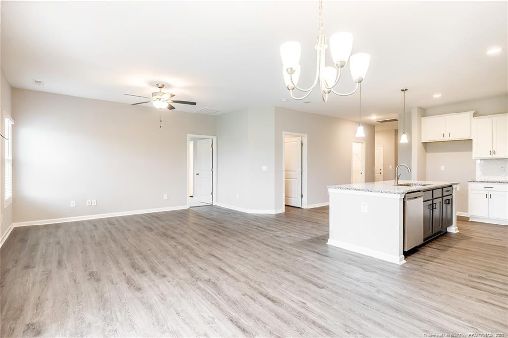 260 Carolina Church Road St. Pauls, NC 28384 - Photo 21 of 32 a view of an empty room and kitchen with wooden floor
