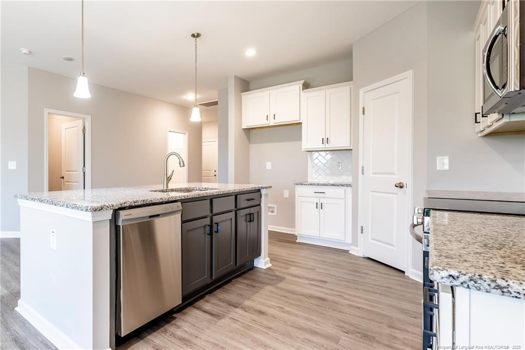 260 Carolina Church Road St. Pauls, NC 28384 - Photo 23 of 32 a kitchen with stainless steel appliances granite countertop a sink a stove a refrigerator and island with wooden floor
