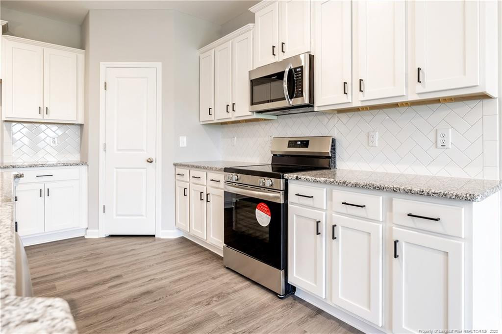 260 Carolina Church Road St. Pauls, NC 28384 - Photo 24 of 32 a kitchen with stainless steel appliances granite countertop a stove a microwave and cabinets