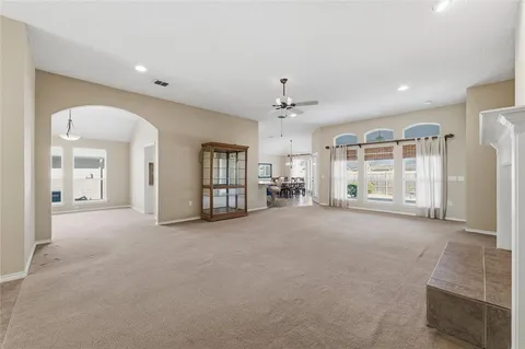 a view of a big room with windows and chandelier