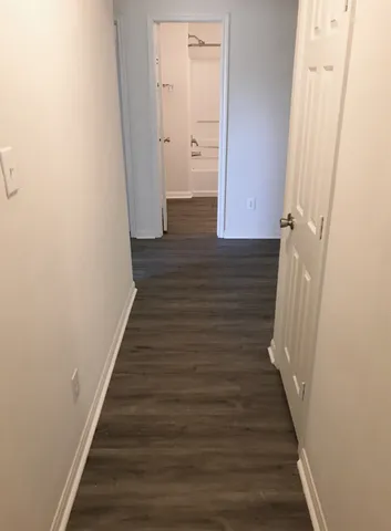 a view of a hallway with wooden floor and staircase