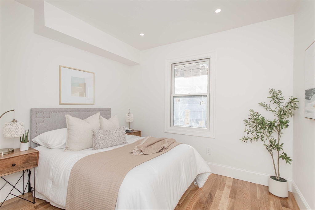 125 Mt Vernon Street, Unit 2 Newton, MA 02465 - Photo 19 of 36 a bedroom with a bed and a potted plant