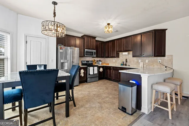 a view of kitchen with granite countertop cabinets table and chairs