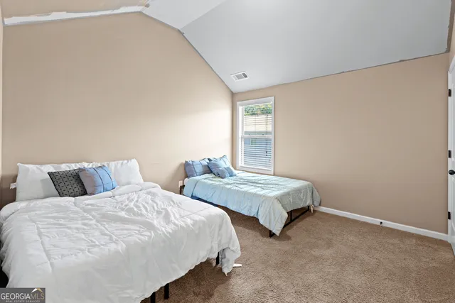 a bedroom with two beds and a window