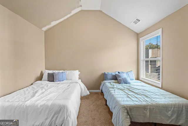 a bedroom with two beds and a window