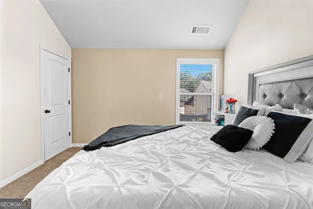 a bedroom with a bed window and walk in closet