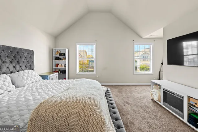 a bedroom with a bed a fireplace and windows