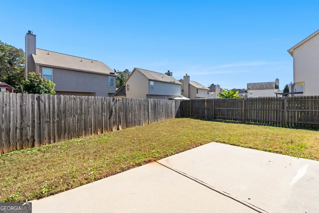 a view of backyard with wooden fence