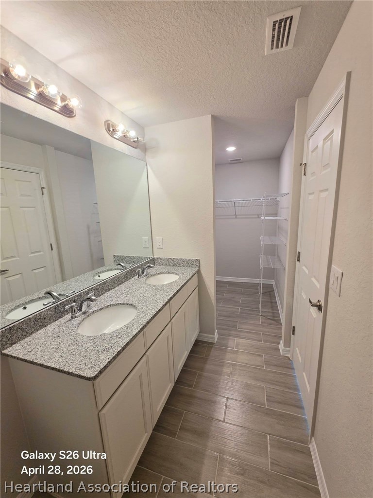 1613 Marble Street Sebring, FL 33870 - Photo 12 of 20 a bathroom with a granite countertop sink a mirror and a shower
