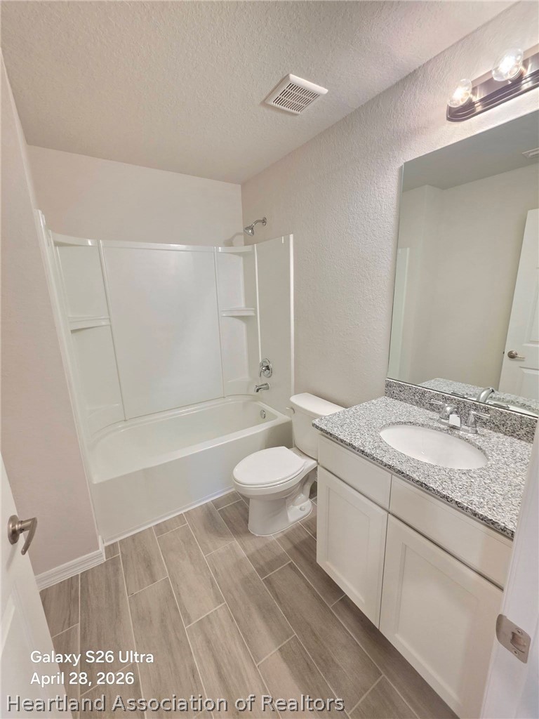 1613 Marble Street Sebring, FL 33870 - Photo 18 of 20 a bathroom with a granite countertop sink toilet a large mirror a shower and bathtub