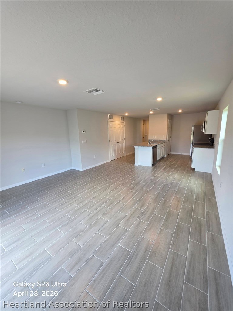 1613 Marble Street Sebring, FL 33870 - Photo 6 of 20 a view of a big room with wooden floor and windows