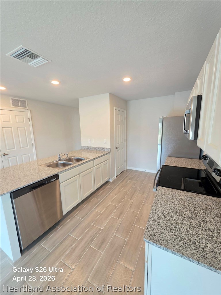 1613 Marble Street Sebring, FL 33870 - Photo 7 of 20 a kitchen with granite countertop a sink and a stove top oven