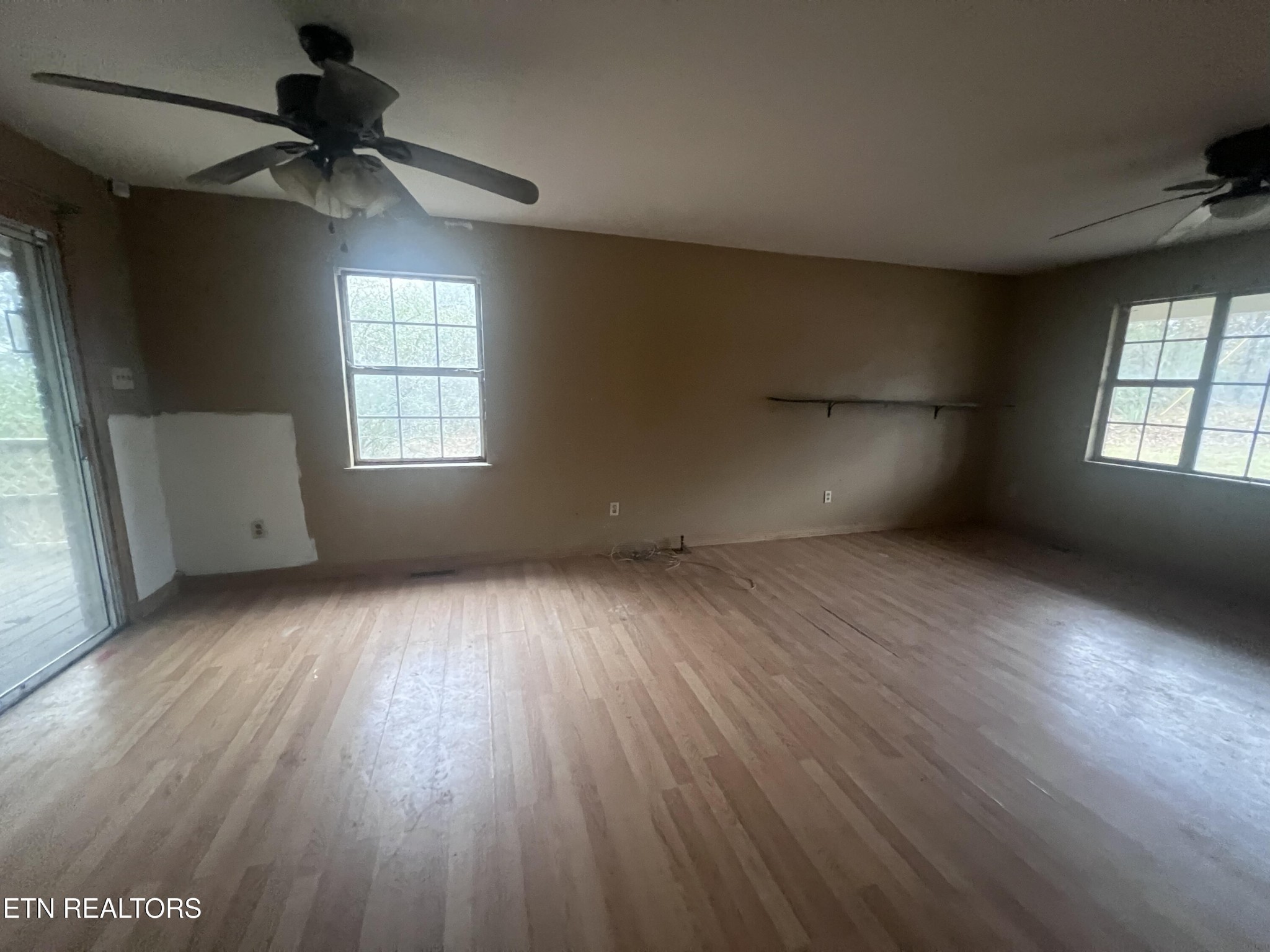 720 Poplar Lane Winfield, TN 37892 - Photo 10 of 19 an empty room with wooden floor and windows