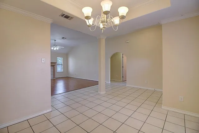 an empty room with wooden floor fireplace and windows