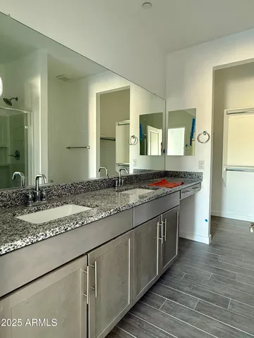 a bathroom with a granite countertop sink and a mirror