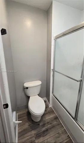 a white toilet sitting next to a shower