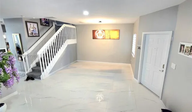 a view of a hallway with entryway window and stairs