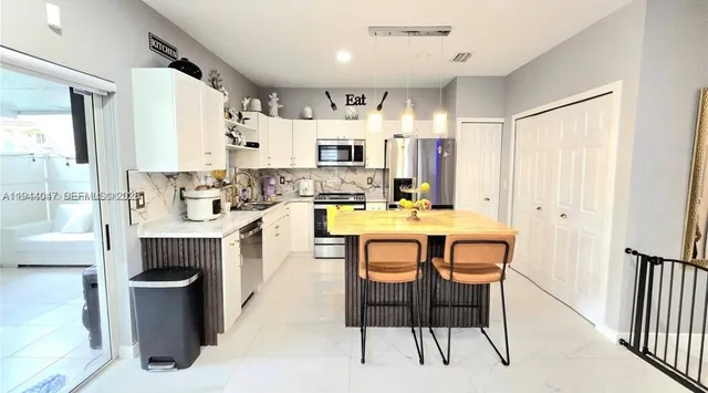 a large kitchen with a table and chairs in it