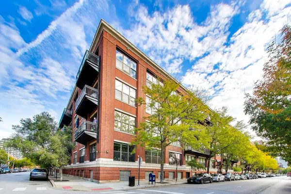 a front view of a building with street view and trees