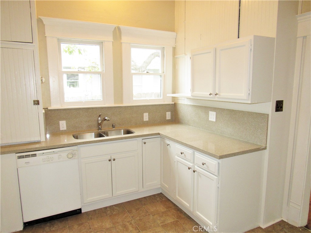 478 South Grand Street Orange, CA 92866 - Photo 8 of 10 a kitchen with white cabinets and a sink