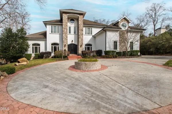 an aerial view of a house with a yard and large trees