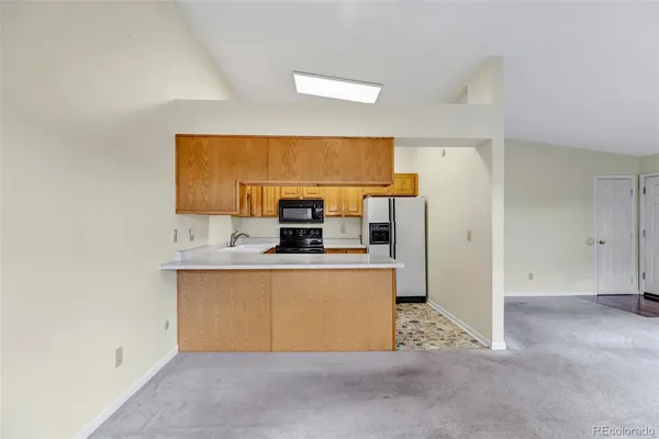 a view of kitchen with stainless steel appliances a sink and a refrigerator