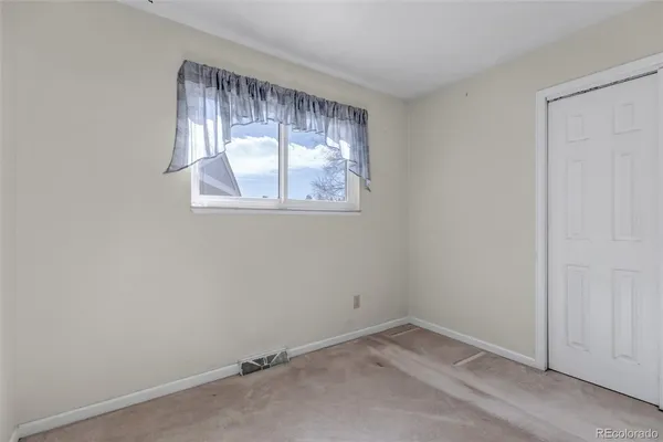 an empty room with windows and closet