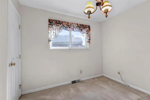 an empty room with a painting on the wall