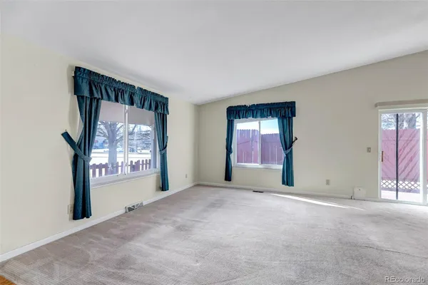 a view of an empty room with window and stairs