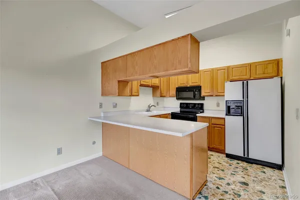 a kitchen with stainless steel appliances a refrigerator a sink a stove a microwave a counter top and cabinets