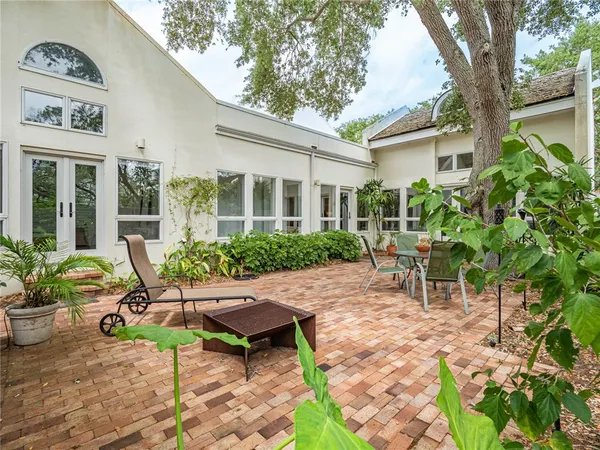 a view of a patio with table and chairs and potted plants