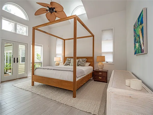 a bedroom with a large bed and a chandelier