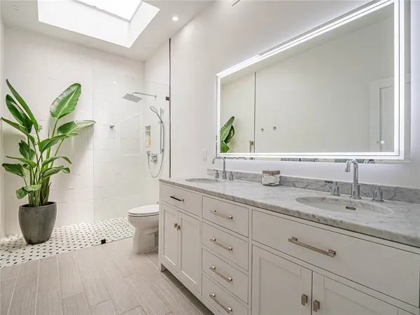 a bathroom with a granite countertop sink a toilet and a mirror