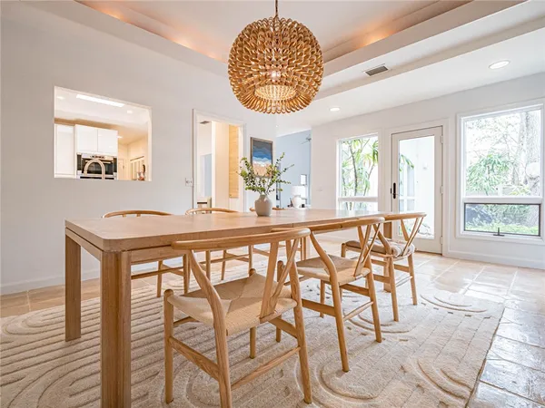 a dining room with furniture and a floor to ceiling window