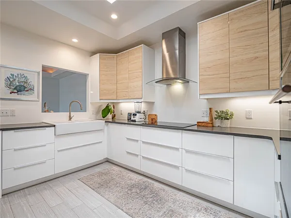 a kitchen with white cabinets and sink