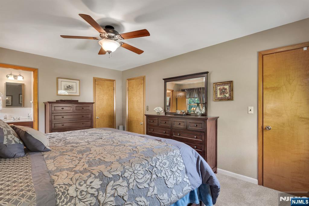 55 Marcia Road Ringwood, NJ 07456 - Photo 15 of 42 a bedroom with a large bed and a chandelier
