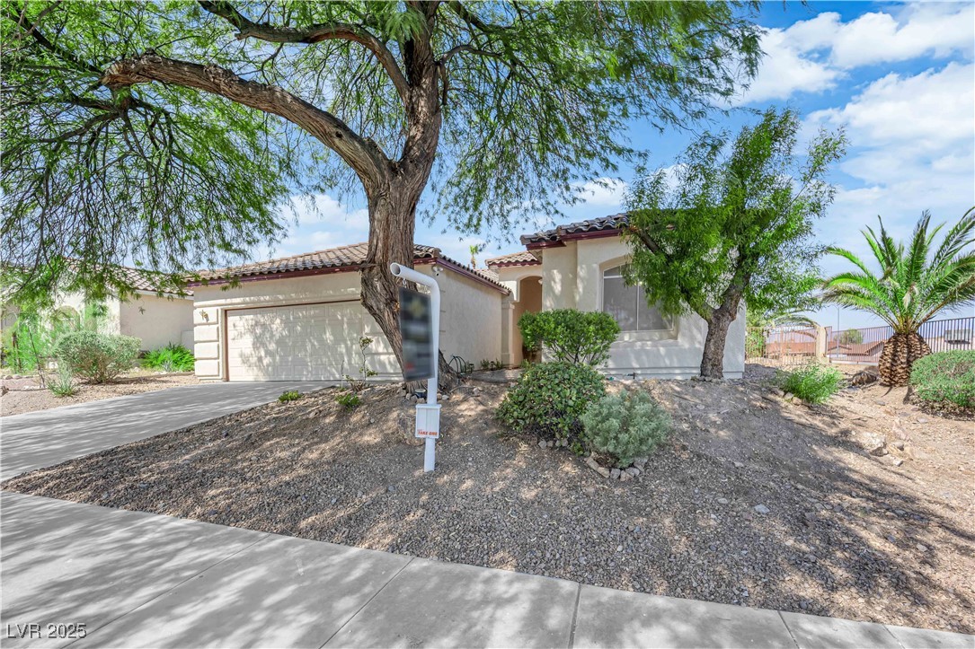 650 West Victory Road Henderson, NV 89015 - Photo 27 of 35 Mediterranean / spanish house featuring concrete driveway, an attached garage, stucco siding, and a tile roof