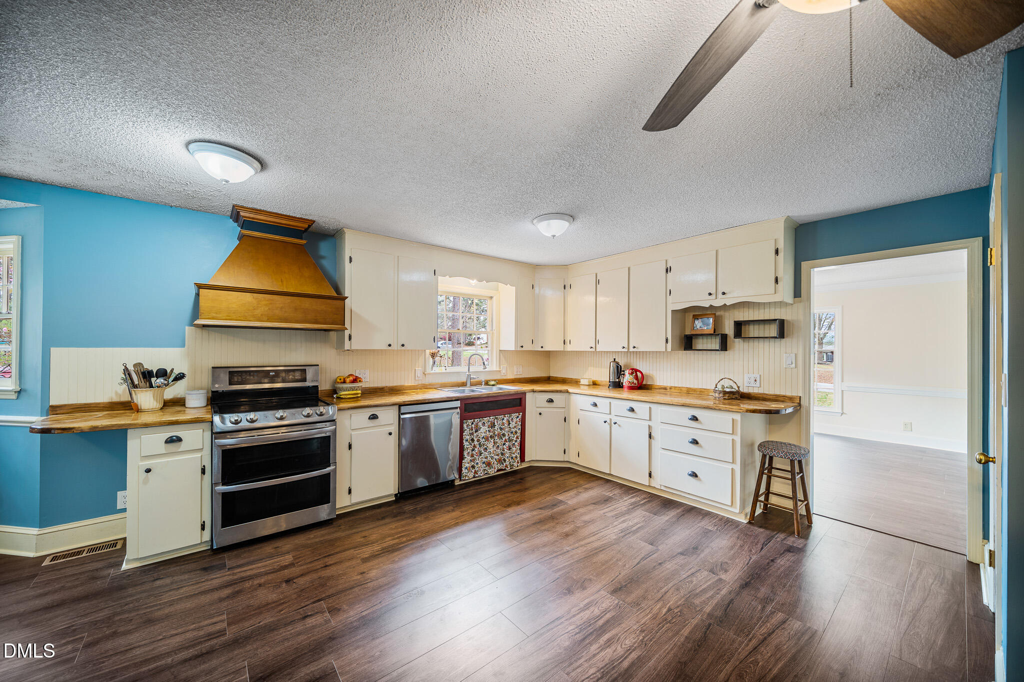 79 South Pleasant Street Angier, NC 27501 - Photo 14 of 52 a kitchen with stainless steel appliances white cabinets a wooden floor and a sink