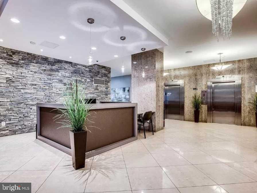 1011 Arlington Boulevard, Unit 1030 Arlington, VA 22209 - Photo 20 of 26 a lobby with a potted plant and a kitchen view