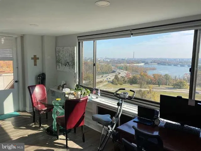 a living room with furniture and a floor to ceiling window