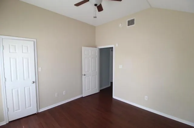 a view of an empty room with wooden floor