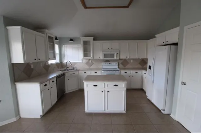 a kitchen with stainless steel appliances a sink stove refrigerator and cabinets